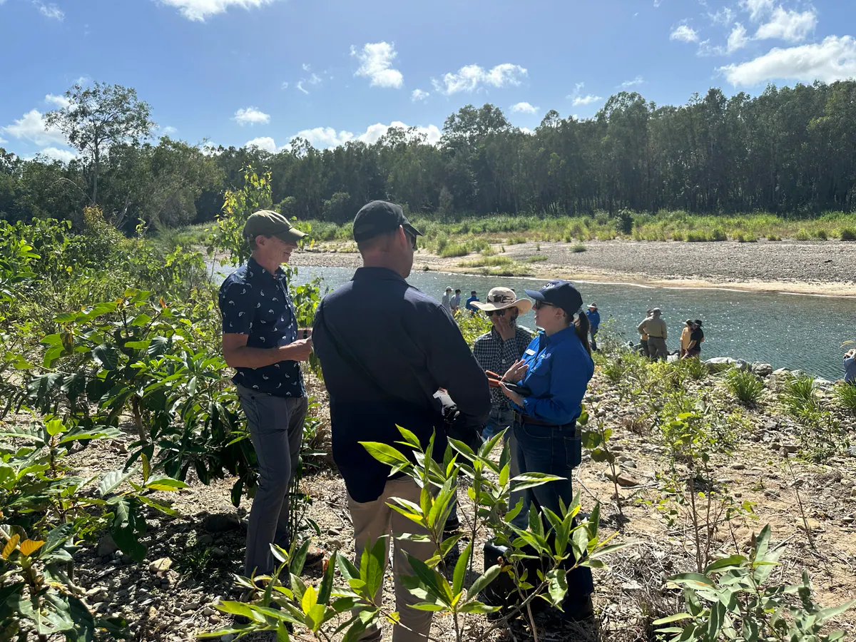 Landholders and staff talking beside a creek